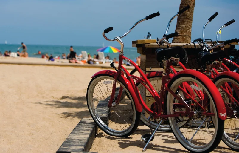 two red bicycles on oak street beach on bright sunny day