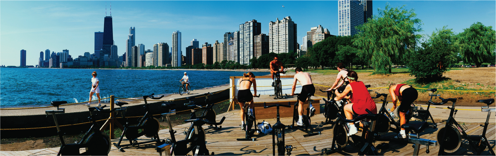 exercise group on stationary bicycles working out together at lakefront trail